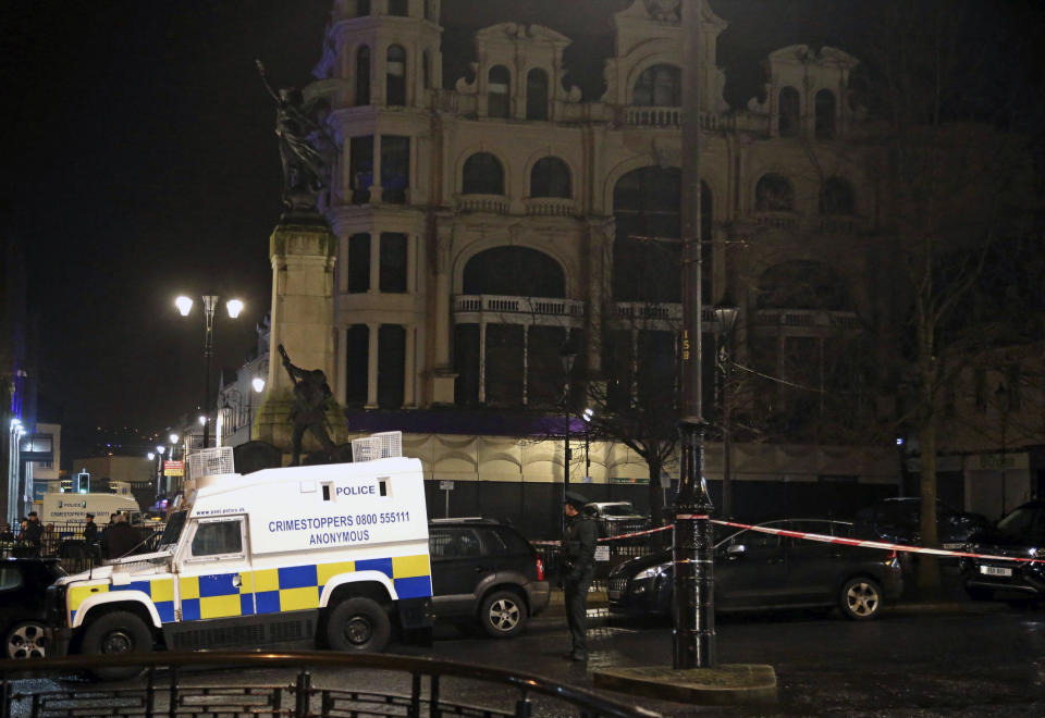 In this photo taken on Saturday, Jan. 19, 2019, police are seen near the scene of a suspected car bomb on Bishop Street in Londonderry, Northern Ireland. Northern Ireland politicians are condemning a car bombing outside a courthouse in the city of Londonderry. The device exploded Saturday night as police, who had received a warning, were evacuating the area. The Police Service of Northern Ireland posted a photograph of a vehicle in flames and urged the public to stay away. (Steven McAuley/PA via AP)