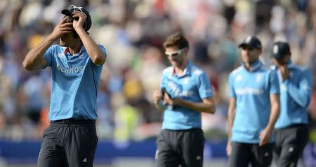 England's captain Alastair Cook (L) leads his team off the field after they were defeated in the fourth one-day international cricket match against India at Edgbaston cricket ground in Birmingham, England September 2, 2014. REUTERS/Philip Brown