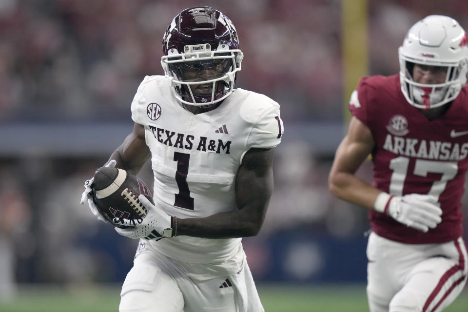 Texas A&M wide receiver Evan Stewart (1) runs for a touchdown against Arkansas defensive back Hudson Clark (17) during the first half of an NCAA college football game, Saturday, Sept. 30, 2023, in Arlington, Texas. (AP Photo/LM Otero)