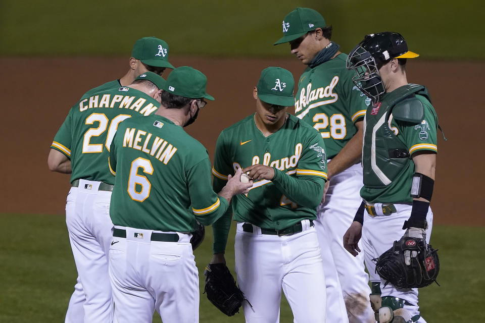 Oakland Athletics starting pitcher Jesus Luzardo, center, is taken out by manager Bob Melvin (6) during the fifth inning of a baseball game against the San Diego Padres in Oakland, Calif., Friday, Sept. 4, 2020. (AP Photo/Tony Avelar)