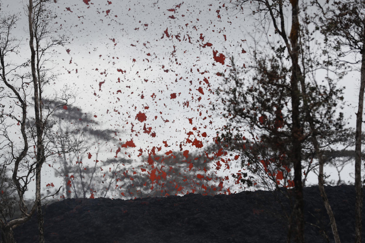 <em>Lava shoot out of a fissure on Pohoiki Rd, near Pahoa, Hawaii, where residents had to cover their faces with masks after a volcano exploded, sending a mixture of pulverised rock, glass and crystal into the air (Picture: AP)</em>