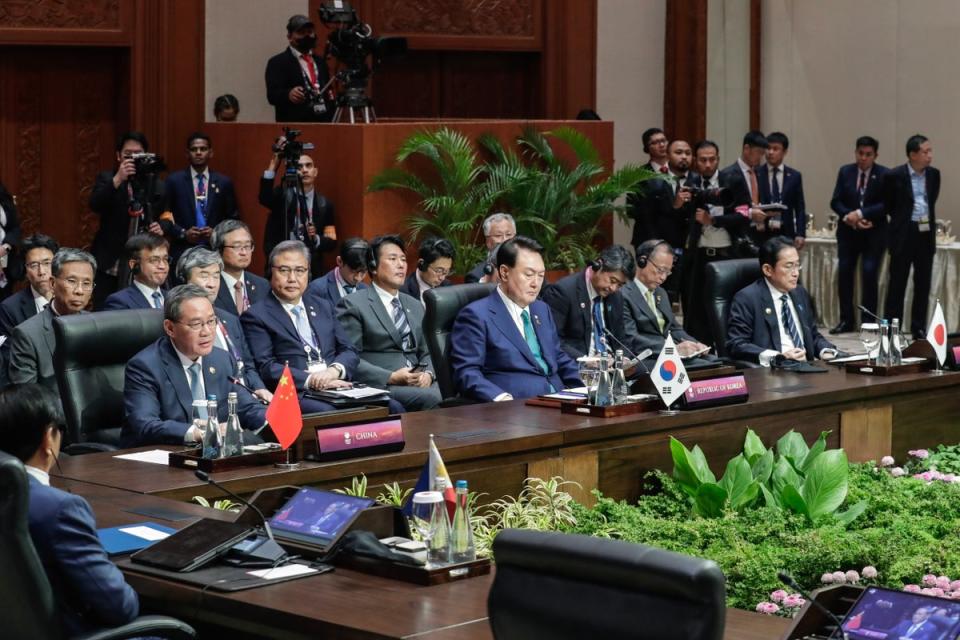 China’s Premier Li Qiang (L) delivers remarks as South Korean president Yoon Suk Yeol (C) and Japan’s prime minister Fumio Kishida (R) listen during the Asean Plus Three (APT) summit (EPA)