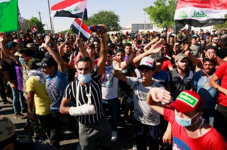 Demonstrators gather at a protest during a curfew, three days after the nationwide anti-government protests turned violent, in Baghdad