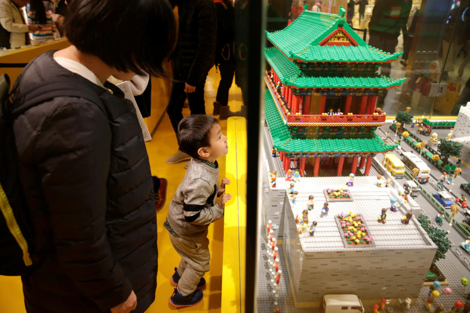 A boy looks at the Zhengyang Gate Tower of Forbidden City made with Lego bricks at a Lego store in Beijing.