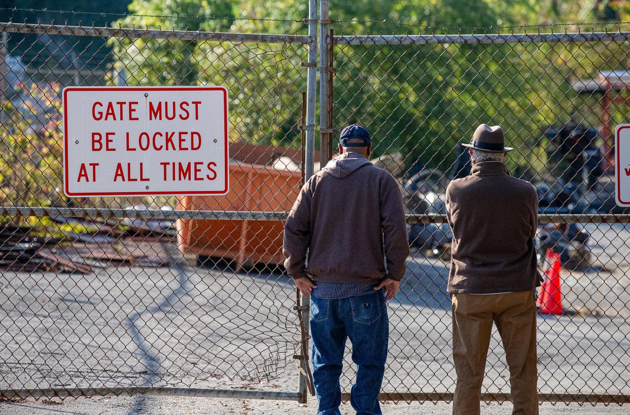Artists Ed Hamilton, right, and William Duffy stand at the locked gates of a city scrapyard on Lexington Rd., looking for art they created for the city of Louisville in the mid-1990s as part of an award-winning, $3.2 million dollar Main Street makeover.