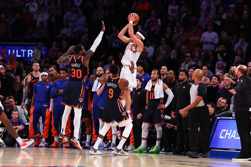 Devin Booker #1 of the Phoenix Suns makes a three-point basket with 1.7 seconds left in the fourth quarter during the game against the New York Knicks at Madison Square Garden on Nov. 26, 2023, in New York City, New York.