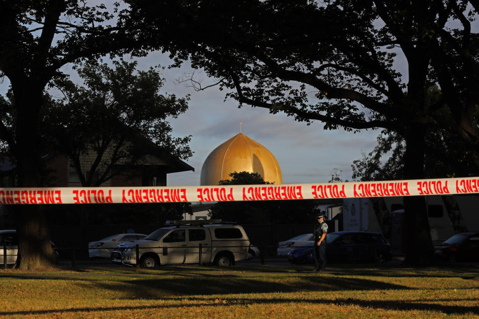 FILE - In this March 17, 2019, file photo, a police officer stands guard in front of the Masjid Al Noor mosque in Christchurch, New Zealand, where one of two mass shootings occurred. Growing certainty that a single gunman was responsible for the attacks renews attention to warnings about the threat of terror attacks by ideologically driven lone actors. But stereotypes of such attackers, often called “lone wolves” in the U.S., risks obscuring the fact that many are not as solitary as some might believe, criminologists say. (AP Photo/Vincent Yu, File)