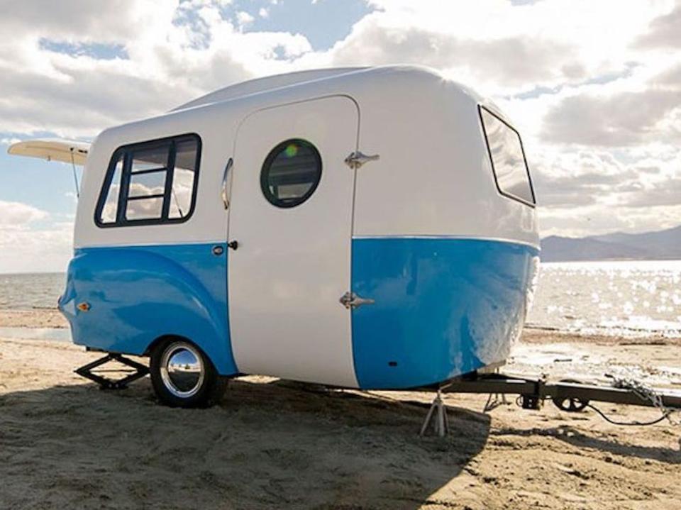 The trailer on a beach near people.