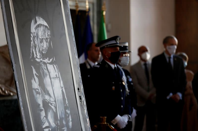 Foto del martes de la ceremonia de entrega a las autoridades de Francia de una puerta del teatro Bataclan con un mural pintado por Banksy recuperada en Italia tras su robo