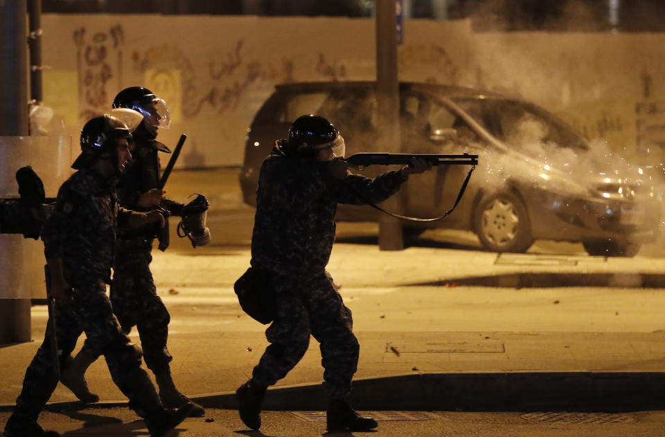 A riot police officer fires rubber bullets against the anti-government protesters trying to enter parliament square, in downtown Beirut, Lebanon, Saturday, Dec. 14, 2019. Lebanon has been facing its worst economic crisis in decades, amid nationwide protests that began on Oct.17 against the ruling political class which demonstrators accuse of mismanagement and corruption. (AP Photo/Hussein Malla)