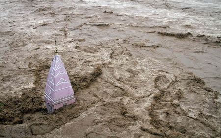 A temple stands amid the waters of the overflowing river Tawi during heavy rains in Jammu September 6, 2014. REUTERS/Mukesh Gupta