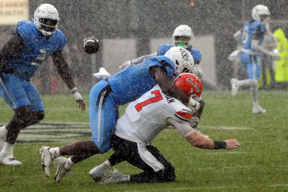 OSU quarterback Alan Bowman (7) is hit by UCF linebacker Jason Johnson as he releases a pass during a rain shower in the first half of the Knights' 45-3 win Saturday in Orlando, Fla.