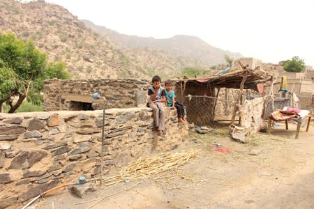 Boys look on as malnourished Muath Ali Muhammad is being taken to a health center in Aslam district of the northwestern province of Hajja