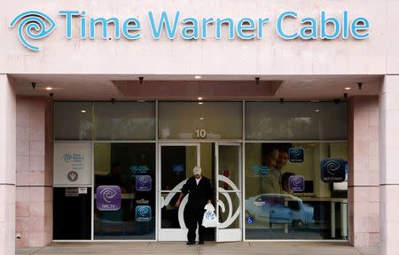 A customer leaves a Time Warner Cable store in Palm Springs, California in this file photo from January 29, 2014. Time Warner Cable Inc is nearing an agreement to be acquired by smaller peer Charter Communications Inc for about $55 billion, combining the second and third largest U.S. cable operators, people familiar with the matter said on May 25, 2015. REUTERS/Sam Mircovich/Files