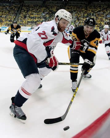 Washington Capitals defenseman Karl Alzner (27) and Pittsburgh Penguins left wing Conor Sheary (43) fight for the puck along the boards during the second period in game three of the second round of the 2016 Stanley Cup Playoffs at the CONSOL Energy Center. The Pens won 3-2. Mandatory Credit: Charles LeClaire-USA TODAY Sports