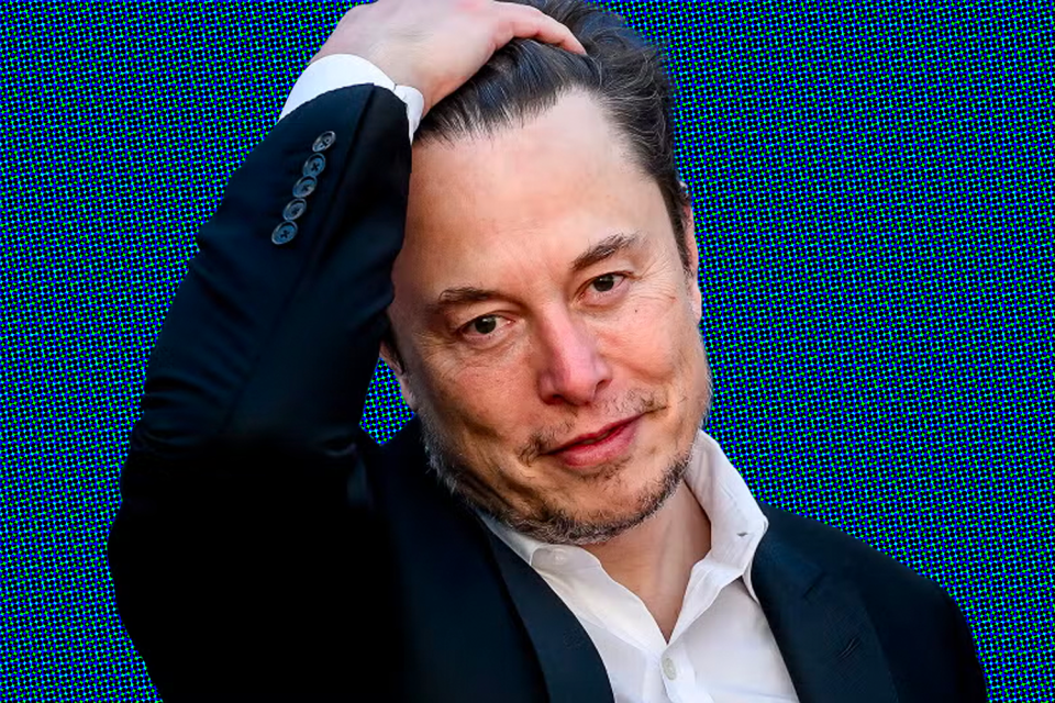 Elon Musk runs his hand through his hair, looking a little sheepish.