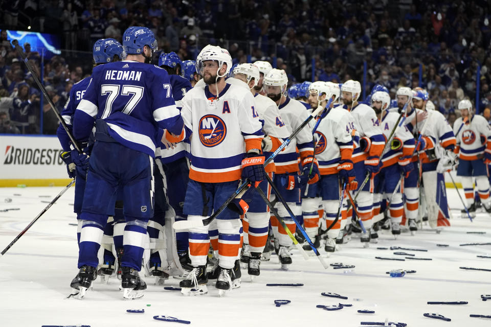 Tampa Bay Lightning defenseman Victor Hedman (77) and his teammates shake hands with New York Islanders right wing Josh Bailey, front right, and his teammates after Game 7 of an NHL hockey Stanley Cup semifinal playoff series Friday, June 25, 2021, in Tampa, Fla. Tampa won the final game 1-0. (AP Photo/Chris O'Meara)