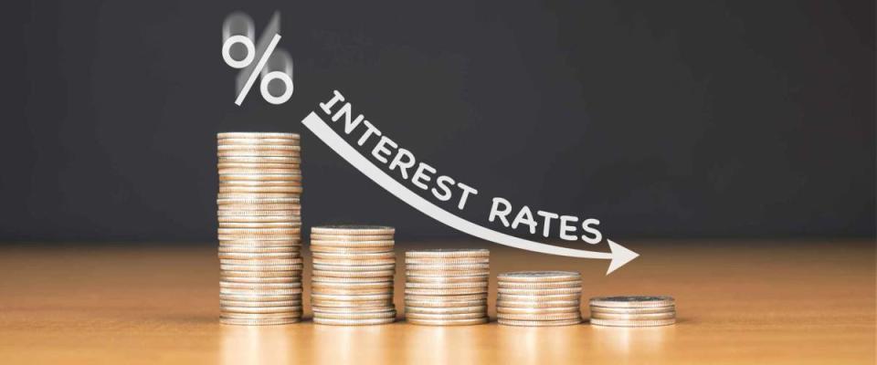 STACKED US QUARTER COINS ON WOODEN TABLE WITH WHITE ILLUSTRATION SHOWS DECREASING OF INTEREST RATES / FINANCIAL CONCEPT