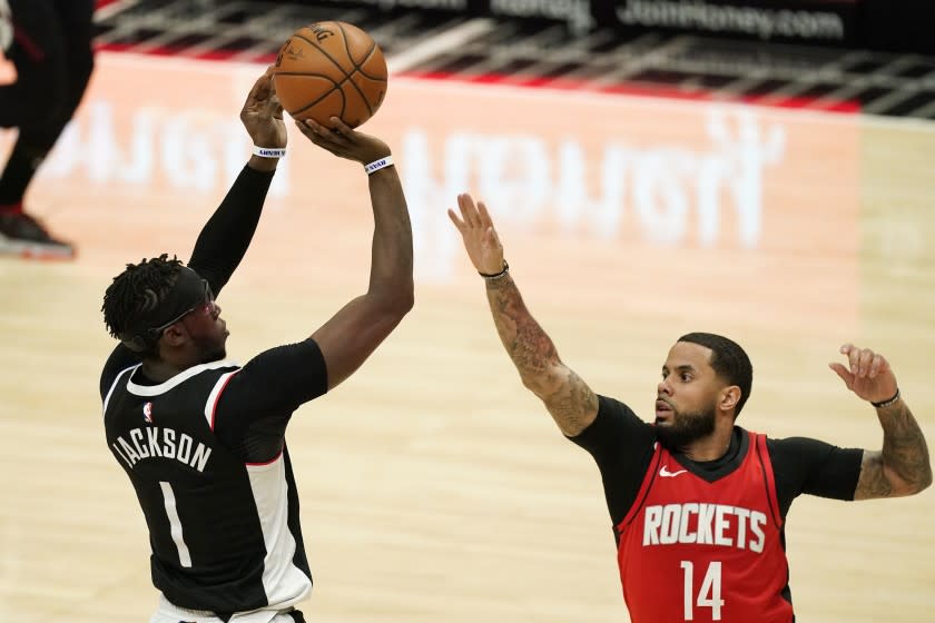 Los Angeles Clippers guard Reggie Jackson, left, shoots as Houston Rockets guard D.J. Augustin defends during the second half of an NBA basketball game Friday, April 9, 2021, in Los Angeles. The Clippers won 126-109. (AP Photo/Mark J. Terrill)