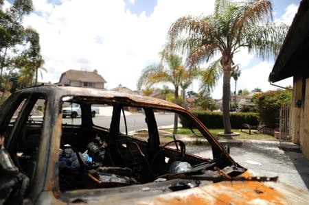 A burned car in the driveway of a suburban home that was the site of a hash oil extraction laboratory explosion is seen in the Mira Mesa area of San Diego