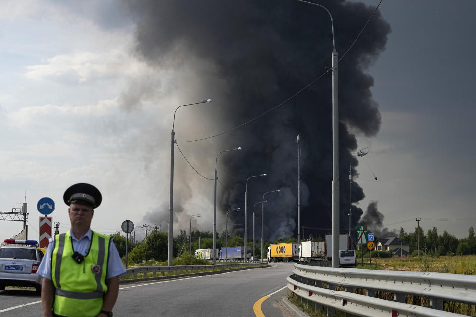 Smoke rises over a burning warehouse of the online retailer Ozon in Istra Municipal District, northwest Moscow Region, Russia, Wednesday, Aug. 3, 2022. The fire, which erupted at the warehouse belonging to Russia's leading online retailer Ozon, has covered the area of 50,000 square meters and injured 11 people, two of whom were hospitalized. (AP Photo/Alexander Zemlianichenko)