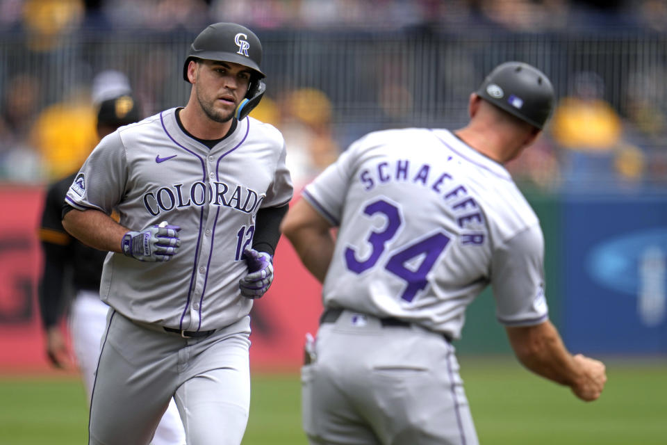 Colorado Rockies' Sean Bouchard (12) rounds third to greetings from third base coach/infield coach Warren Schaeffer (34) after hitting a solo home run off Pittsburgh Pirates starting pitcher Bailey Falter during the second inning of a baseball game in Pittsburgh, Sunday, May 5, 2024. (AP Photo/Gene J. Puskar)