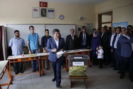 Turkish Prime Minister Ahmet Davutoglu (C) prepares to cast his ballot at a polling station during the parliamentary election in Konya, Turkey, June 7, 2015. REUTERS/Umit Bektas