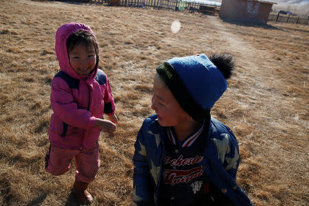 Ukhaanzaya Gankhuyag, 5, and Namuun (R), 5, play outside their Mongolian ger in Tov province outside Ulaanbaatar, Mongolia January 30, 2019. Picture taken January 30, 2019. REUTERS/B. Rentsendorj