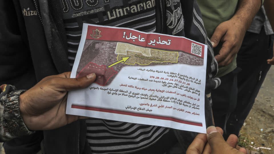 Palestinians hold an evacuation order leaflet dropped by Israel's military in the east of the city of Rafah on May 6, 2024 - Abed Rahim Khatib/dpa/picture-alliance/AP