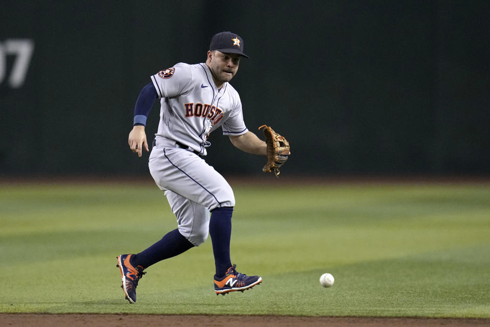 Houston Astros second baseman Jose Altuve runs over to field a grounder on an infield single hit by Arizona Diamondbacks' Tommy Pham during the third inning of a baseball game, Saturday, Sept. 30, 2023, in Phoenix. (AP Photo/Ross D. Franklin)