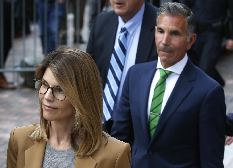 Lori Loughlin, left, leaves as her husband Mossimo Giannulli, right, trails behind her outside of the John Joseph Moakley United States Courthouse in Boston on April 3, 2019. (Photo by Jessica Rinaldi/The Boston Globe via Getty Images)