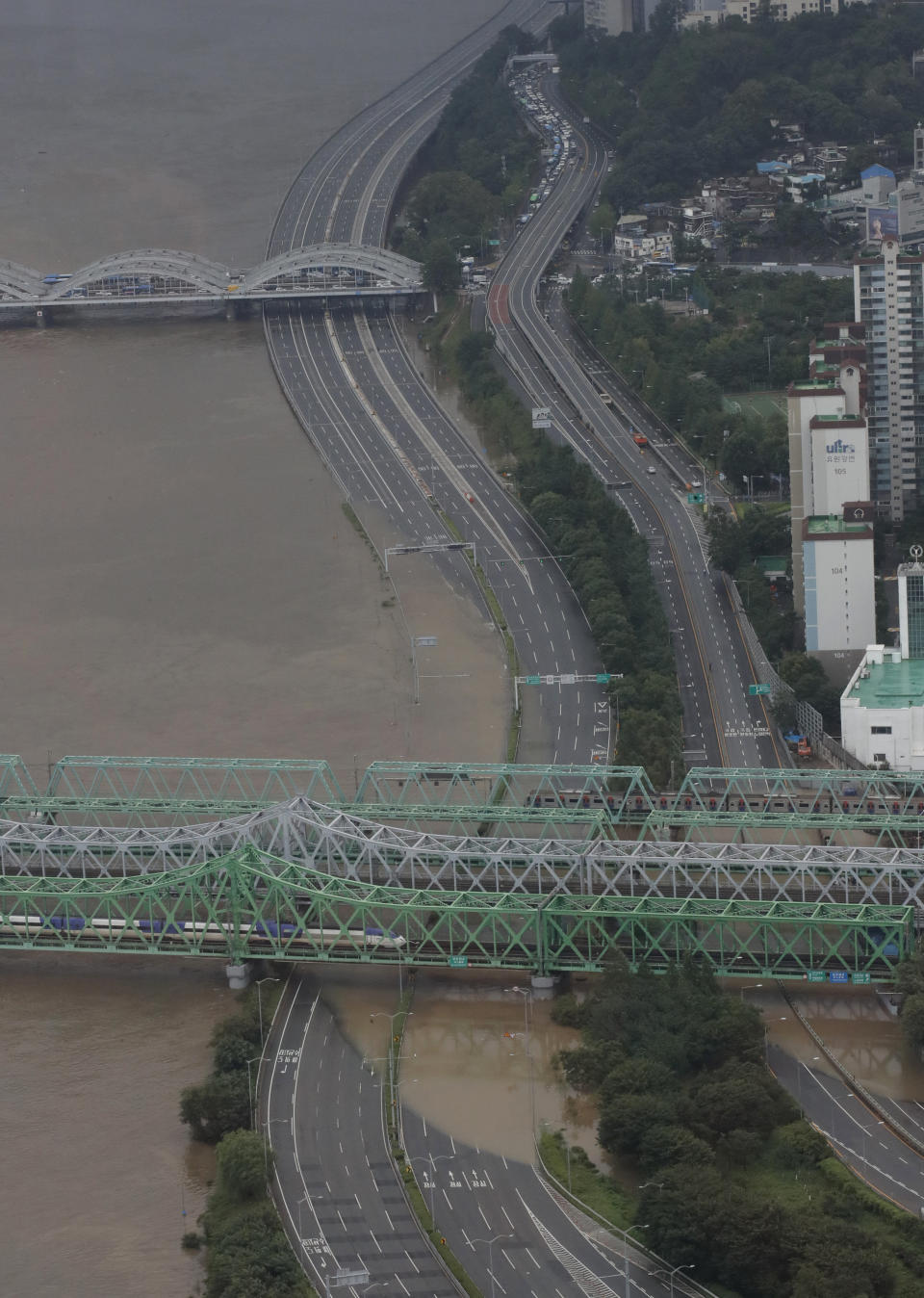 A part of a main road near the Han River is flooded due to heavy rain in Seoul, South Korea, Thursday, Aug. 6, 2020. Torrential rains continuously pounded South Korea on Thursday, prompting authorities to close parts of highways and issue a rare flood alert near a key river bridge in Seoul. (AP Photo/Lee Jin-man)