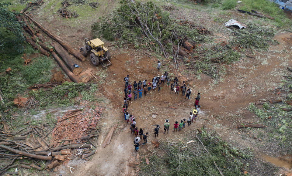 Guarani Mbya protesters stand in a circle and sing a mourning song for the trees cut by real estate developer Tenda which is making way for apartment buildings on property next to their indigenous community in Sao Paulo, Brazil, Thursday, Jan. 30, 2020. The tension between a builder with projects in nine Brazilian states and a 40-family indigenous community is a microcosm of what’s playing out elsewhere in the country. (AP Photo/Andre Penner)