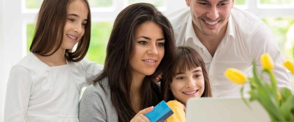 Family shopping online, two twins girls  wit father and mother enjoying in shopping