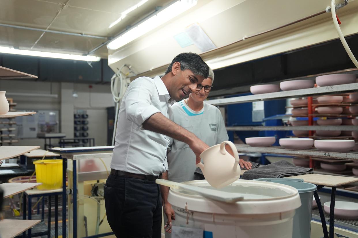 Rishi Sunak dipping pots with staff member Georgia Plinston during his visit to Denby Pottery Factory (Joe Giddens/PA Wire)
