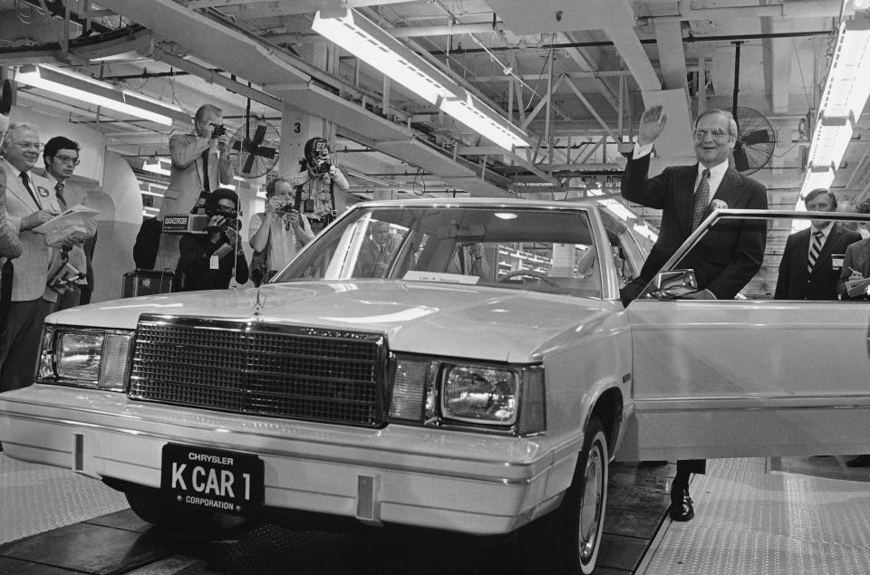 FILE - In this Aug. 6, 1980, file photo, Chrysler Chairman Lee Iacocca, right, waves as he steps into the first K-Car at ceremonies in Detroit, Mich. The new front-wheel-drive compact was the driven out of the plant past cheering auto workers by Iacocca. Former Chrysler CEO Iacocca, who became a folk hero for rescuing the company in the '80s, has died, former colleagues said Tuesday, July 2, 2019. He was 94. (AP Photo/Dale Atkins, File)