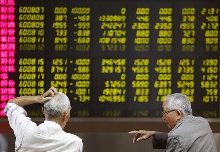 Investors chat as they watch a board showing stock prices at a brokerage office in Beijing, China, July 6, 2015. REUTERS/Kim Kyung-Hoon