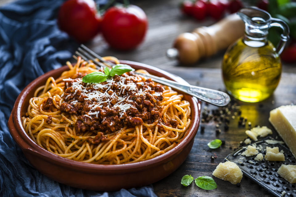 Teller mit Spaghetti Bolognese auf einem Holztisch