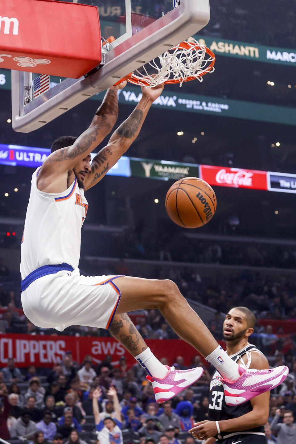 New York Knicks forward Obi Toppin, left, dunks the Los Angeles Clippers during the first half of an NBA basketball game Saturday, March 11, 2023, in Los Angeles. (AP Photo/Ringo H.W. Chiu)