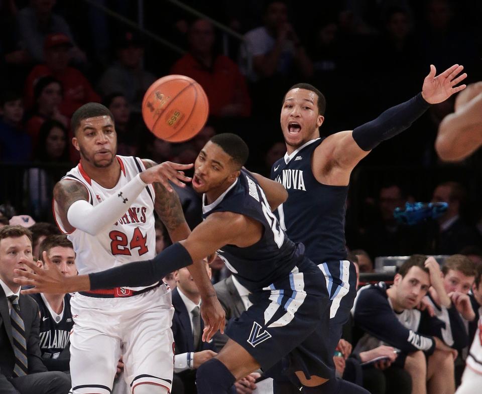 St. John's Ron Mvouika, left, of France, passes away from Villanova's Mikal Bridges, center, and Jalen Brunson. right, during the first half of an NCAA college basketball game Sunday, Jan. 31, 2016, in New York. (AP Photo/Frank Franklin II)