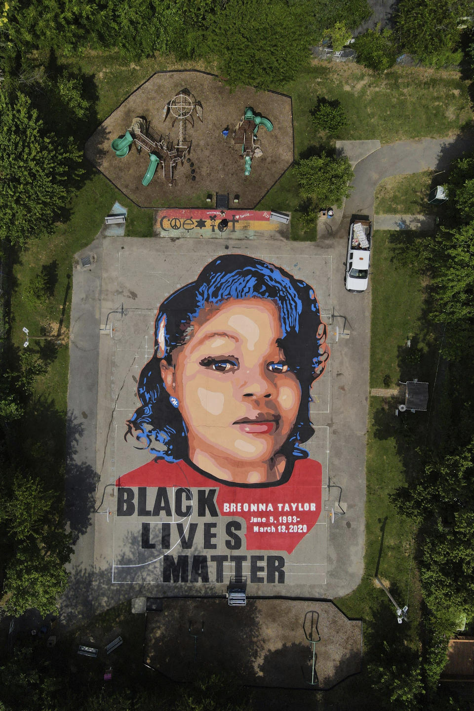 A ground mural depicting a portrait of Breonna Taylor is seen at Chambers Park, Monday, July 6, 2020, in Annapolis, Md. The mural honors Taylor, a 26-year old Black woman who was fatally shot by police in her Louisville, Ky., apartment. The artwork was a team effort by the Banneker-Douglass Museum, the Maryland Commission on African American History and Culture, and Future History Now, a youth organization that focuses on mural projects. (AP Photo/Julio Cortez)