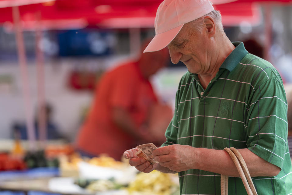 A customer counts notes of Croatian Kuna at the vegetable market in downtown Zagreb, Croatia, Tuesday, July 12, 2022. The European Union is set to remove the final obstacles for Croatia to adopt the euro, ensuring the first expansion of the currency bloc in almost a decade. (AP Photo/Darko Bandic)