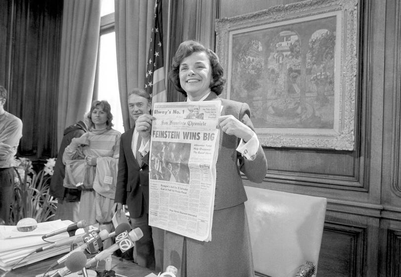 San Francisco Mayor Dianne Feinstein holds up the headlines in her office in San Francisco, Wednesday, April 27, 1983 following her sweeping victory in Tuesday's recall election. The recall was organized by the White Panthers who were angered at her support for gun control. (AP Photo/Paul Sakuma)