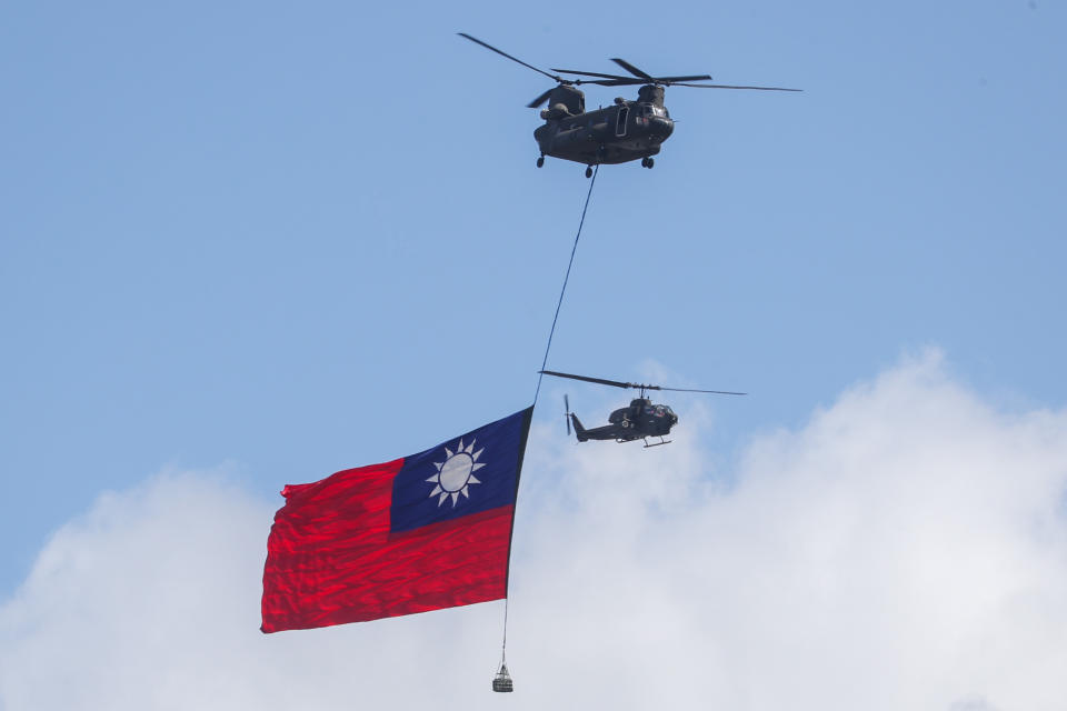 雙十國慶大會10日舉行，亮點之一國軍CH-47運輸直升機吊掛歷年最大國旗，在阿帕契與眼鏡蛇直升機伴隨下飛越總統府前廣場上空。（中央社）