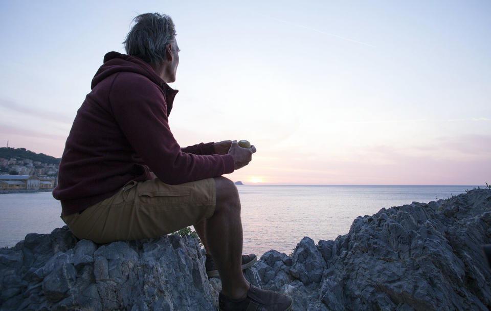 Man watching sunrise as sea (Getty Images)