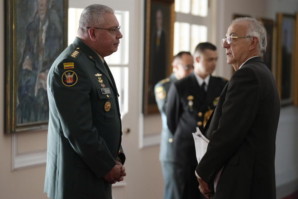 Colombia's Armed Forces Commander, Gen. Helder Giraldo, left, and Colombia's Defense Minister Ivan Velasquez, wait for the arrival of Colombia's President Gustavo Petro, to attend a joint press conference at the Narino Presidential Palace in Bogota, Colombia, Tuesday, April 30, 2024. Velásquez told lawmakers on Tuesday that no new contracts will be signed with Israel but that existing ones will be fulfilled. (AP Photo/Fernando Vergara)