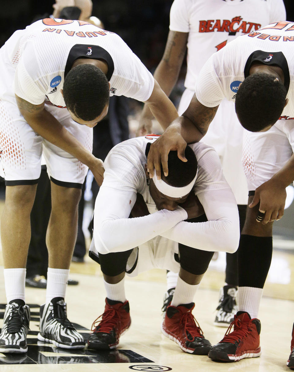 Cincinnati’s Troy Caupain, left, and Jermaine Sanders, right, speak with Justin Jackson after their 61-57 loss to Harvard in the second-round of the NCAA college basketball tournament in Spokane, Wash., Thursday, March 20, 2014. (AP Photo/Young Kwak)