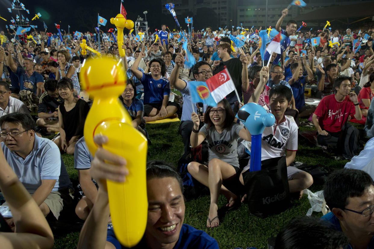 Supporters of the Worker's Party cheer as they wait for results at an assembly center in Singapore, Friday, Sept. 11, 2015.  Singaporeans voted Friday in general elections whose results hold no surprises - the ruling People's Action Party will extend its 50-year-rule by another five years. But what will be closely watched is the percentage of votes it garners, which will determine the measure of its popularity as the city-state goes through tough economic times. (AP Photo/Ng Han Guan)