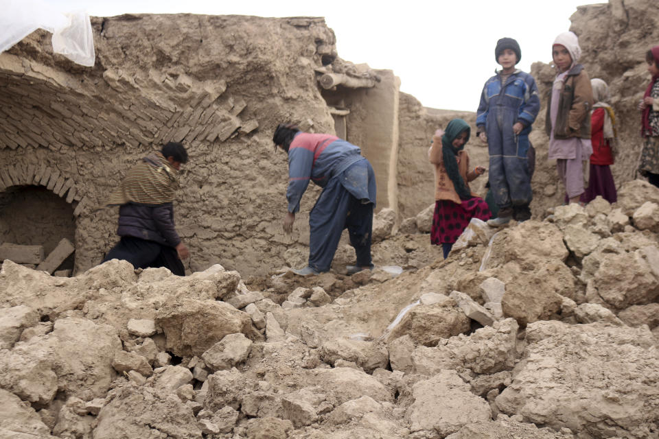 Afghan villagers remove bricks after their home was damaged by Monday's earthquake in the remote western province of Badghis, Afghanistan, Tuesday, Jan. 18, 2022. The United Nations on Tuesday raised the death toll from Monday's twin earthquakes in western Afghanistan, saying three villages of around 800 houses were flattened by the temblors. (Abdul Raziq Saddiqi)