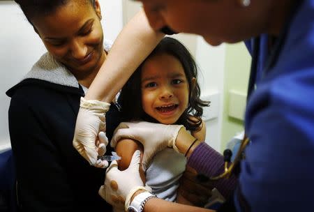 Jayden Mercado, 4, sits in his mother Yariluz Ocasio's lap while he gets an influenza vaccine at Boston Children's Hospital in Boston, Massachusetts in this file photo taken January 10, 2013. REUTERS/Brian Snyder/Files